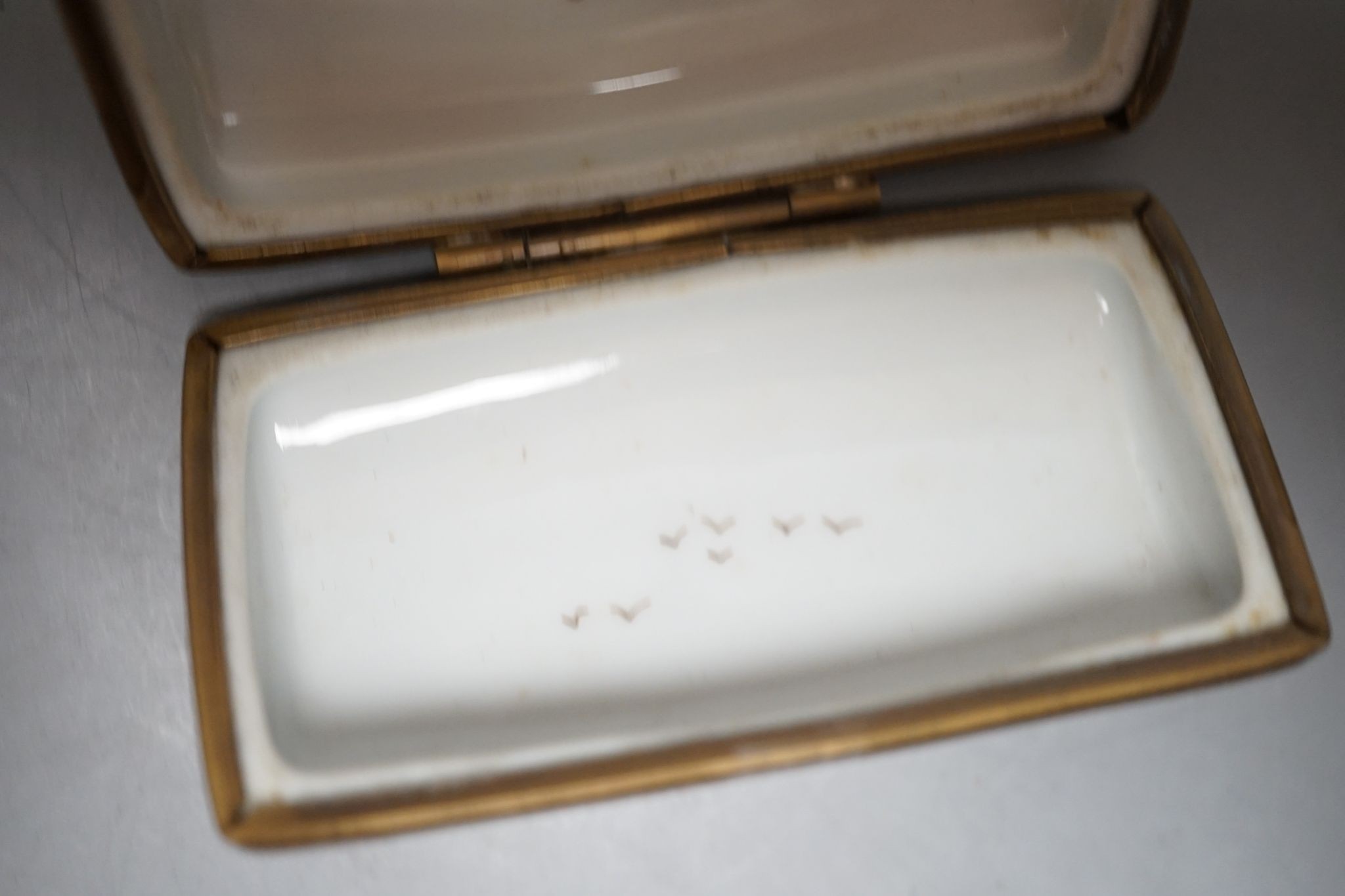A Russian oval lacquered box, 10cm., and a porcelain box painted with ships approaching harbour